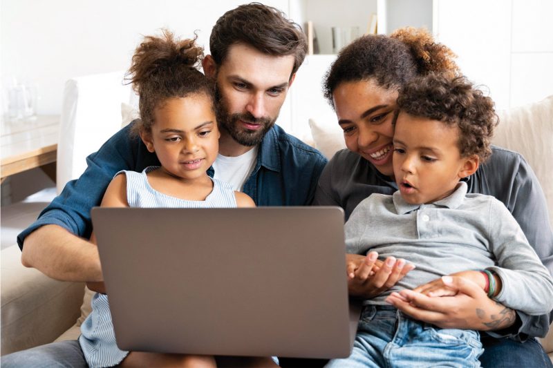 famille regardant un ordinateur ensemble pour remplir l'enquête sociale